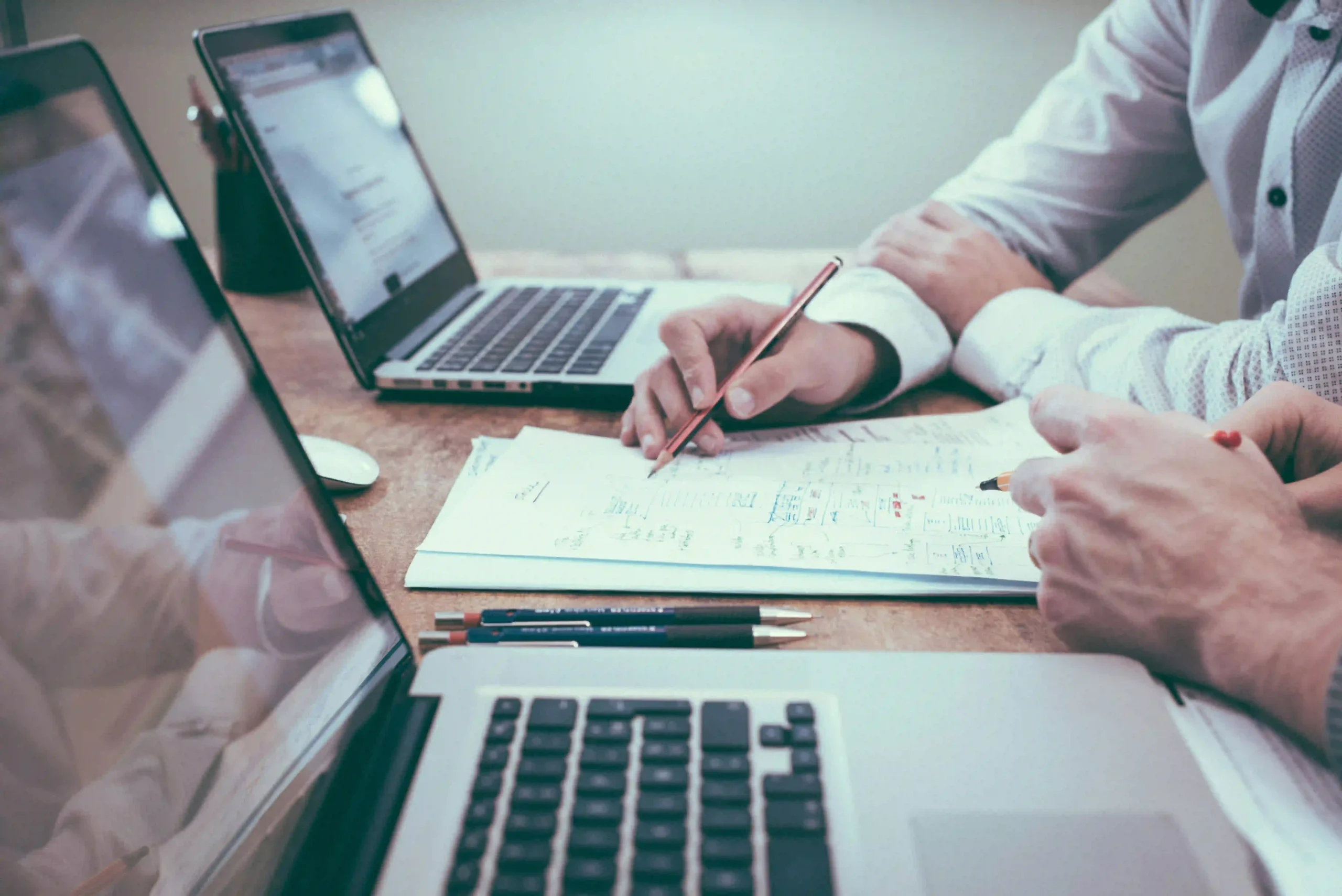 two persons look at data on laptops for blog " The Role of CROs in Real World Data in Clinical Trials "
