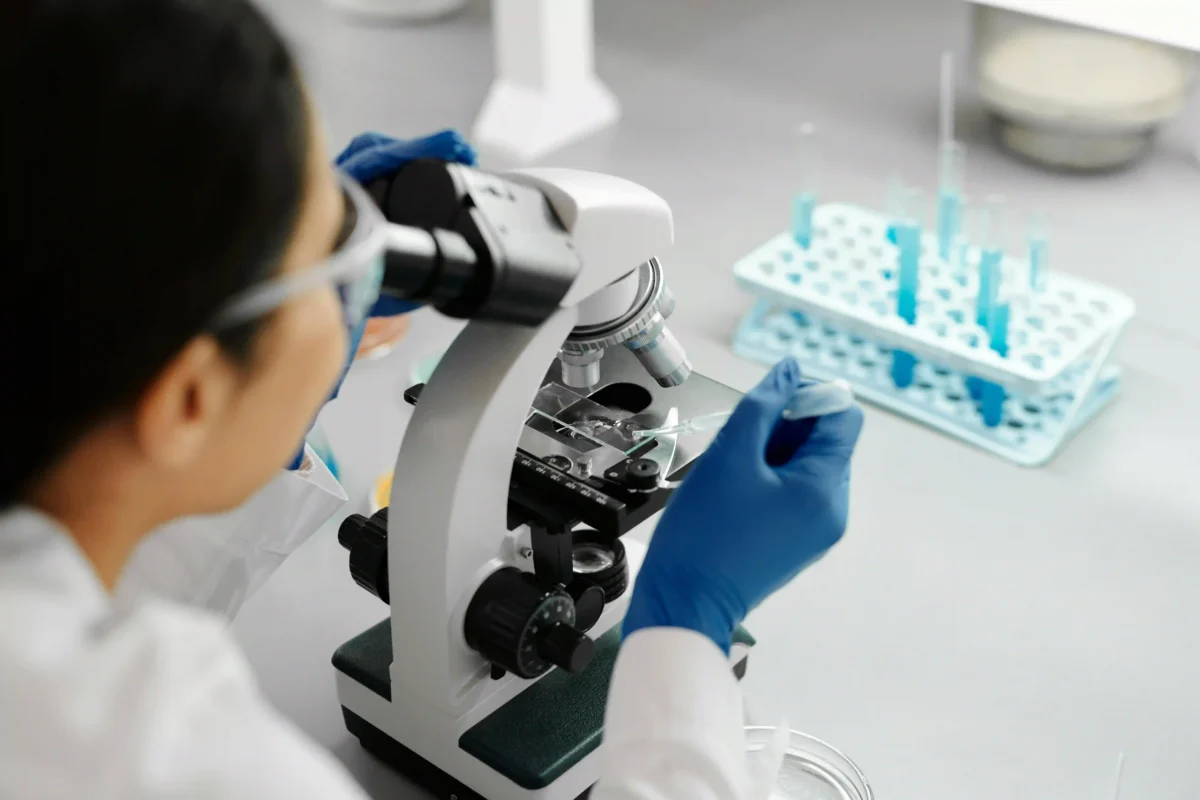 a person in a lab looking at a sample for a blog about clinical trials management